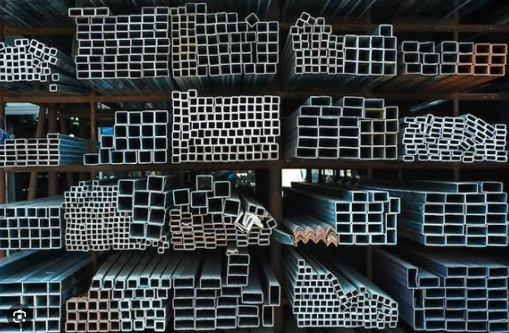 Hollow metal sections stored in rows inside a factory